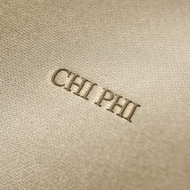 Soft beige fabric close-up showing a smooth, heavyweight knit texture with gentle folds and subtle draping.