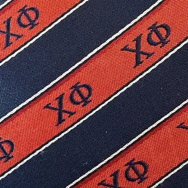Closeup image of a Chi Phi striped silk neck tie.