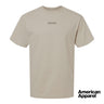 Beige short sleeve crewneck t-shirt with small embroidered text at the center chest on a clean background.