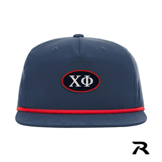 A navy blue performance snapback hat featuring a red rope detail and a central navy oval patch with a red embroidered border.